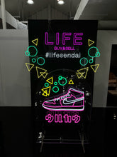 画像をギャラリービューアに読み込む, アパレルショップ店内に設置されたピンク・ホワイト・イエロー・グリーンのカラフルなネオンサインロゴ
