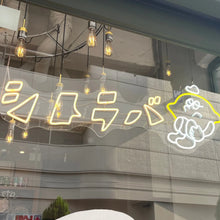 画像をギャラリービューアに読み込む, 店の窓際に設置されたイエローとホワイトのネオンサインロゴ