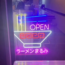 画像をギャラリービューアに読み込む, ラーメン屋の入り口に設置されたイエロー・ブルー・レッド・ピンク・ホワイトのカラフルなネオンサインロゴ