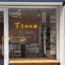 画像をギャラリービューアに読み込む, カフェ店内のガラスから、設置されたオレンジのネオンサインロゴが見える外観