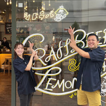 画像をギャラリービューアに読み込む, 店前でネオンサインを指差して笑う女性店長とオーナー
