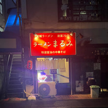 画像をギャラリービューアに読み込む, ラーメン屋夜の外観　目を惹く赤いお店の看板とカラフルに光るネオンサインロゴ

